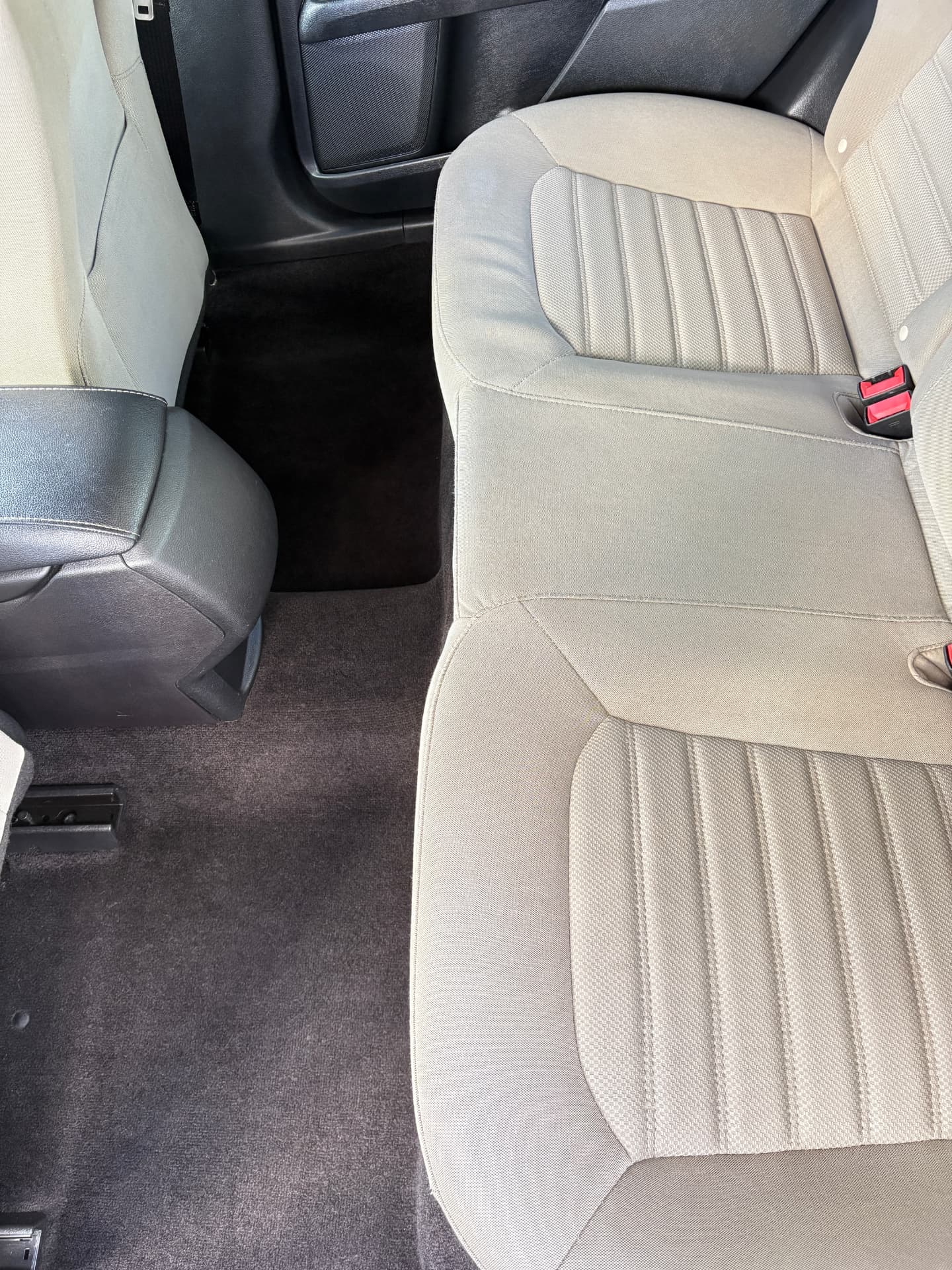 Freshly shampooed cloth rear seats and vacuumed carpet in a sedan after interior detailing