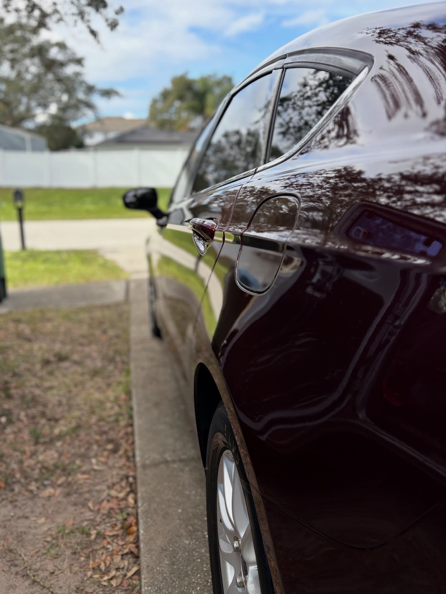 Deep burgundy sedan with mirror-finish paint after a full exterior detail and polish